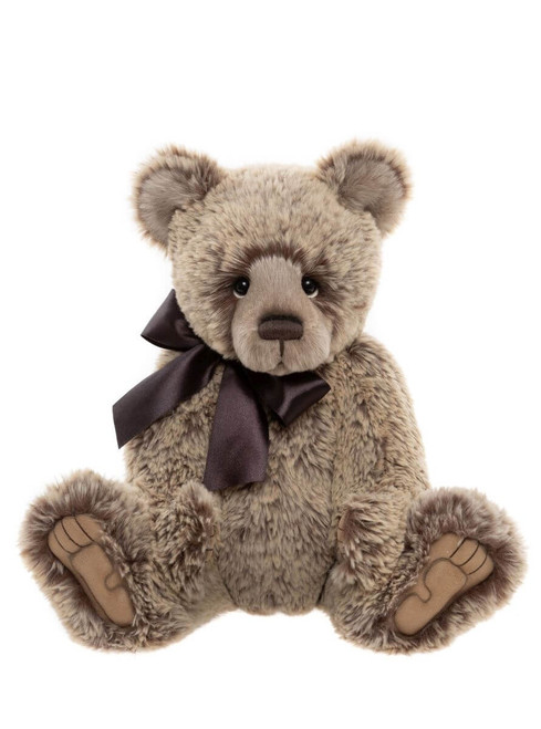 A fluffy, brown-grey Charlie Bears teddy bear sits upright against a white background, wearing a dark satin bow tie around its neck.