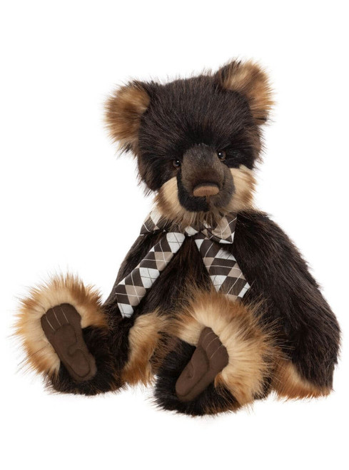 A dark brown and tan Charlie Bears teddy bear sits upright, wearing an argyle bow tie, with tan-tipped ears, muzzle, and paws, against a white background.