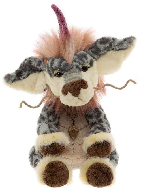 A fantasy-themed Charlie Bears plush creature sits upright, featuring grey mottled fur, large ears, a pink mohawk mane, a single purple horn, whiskers, and an acorn pendant necklace.