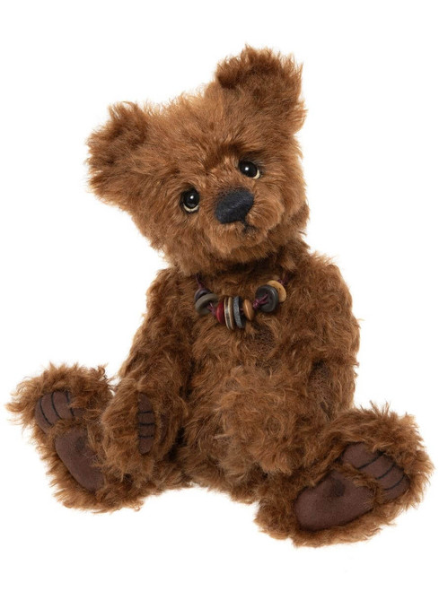 A fluffy brown Charlie Bears teddy bear sits upright against a white background, adorned with a small decorative button cluster at its chest, featuring dark paw pads and glossy eyes.