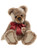 A plush Charlie Bear teddy sits upright, featuring mottled beige-brown fur, oversized paws facing forward, dark eyes, and a shiny red satin bow tied at its neck.