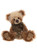 A curly, golden-brown Charlie Bears teddy bear sits upright against a white background, wearing an olive-green bow tied at the neck with a small brass jingle bell.