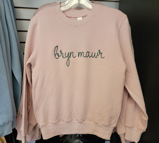 Rose color sweater with bryn mawr written in cursive in green