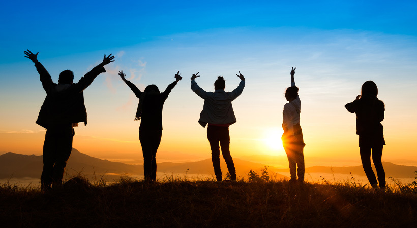 Summit celebration Five people on a mountain summit at sunset