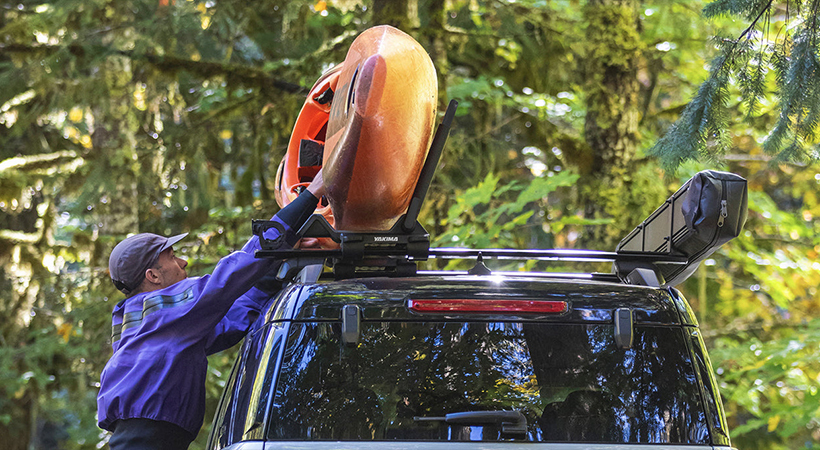 Paddler securing a kayak to a roof rack on top of a vehicleSummer Favorites