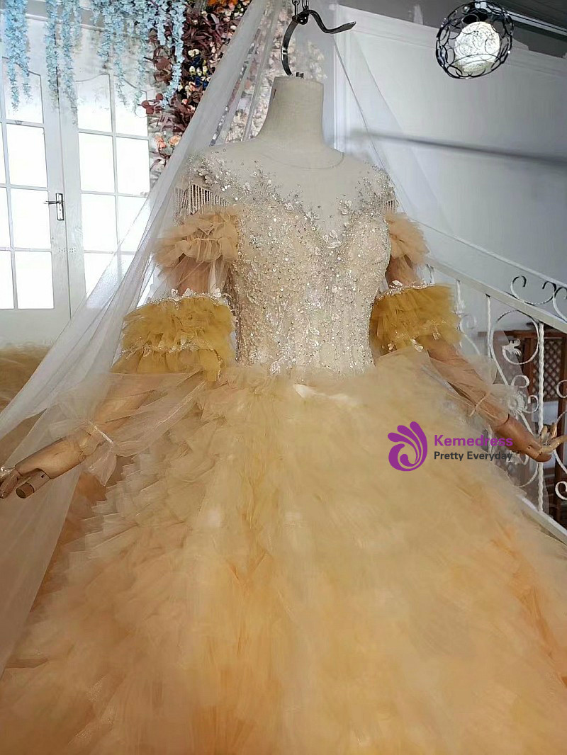 Yellow long sleeve wedding gown with open back appearance and full tulle ball gown skirt