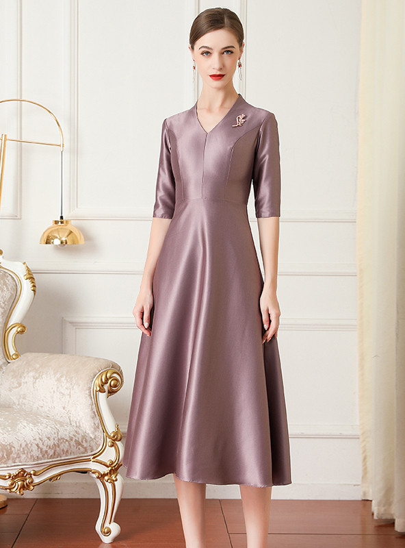Mauve satin tea length mother of the bride dress with V neck and shoulder brooch