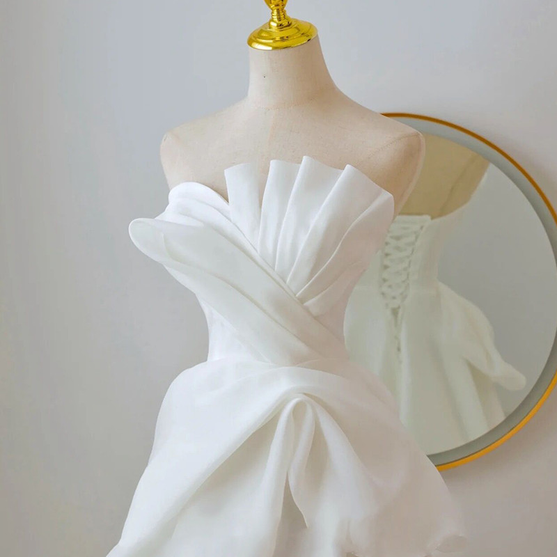 Ivory white wedding dress with architectural pleated strapless bodice and oversized fabric bow