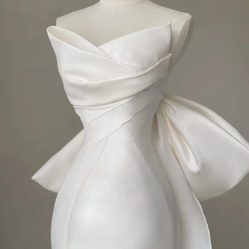 Ivory satin strapless mermaid wedding dress with oversized bow and detachable train