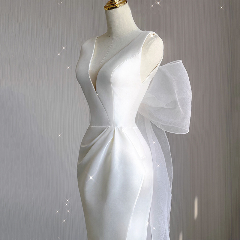 White satin V-neck wedding dress detail with draped waist and high front slit