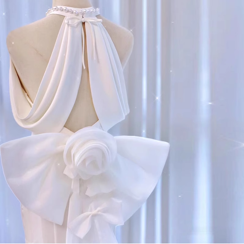 Large pearl satin bow on the back of a white mermaid wedding dress