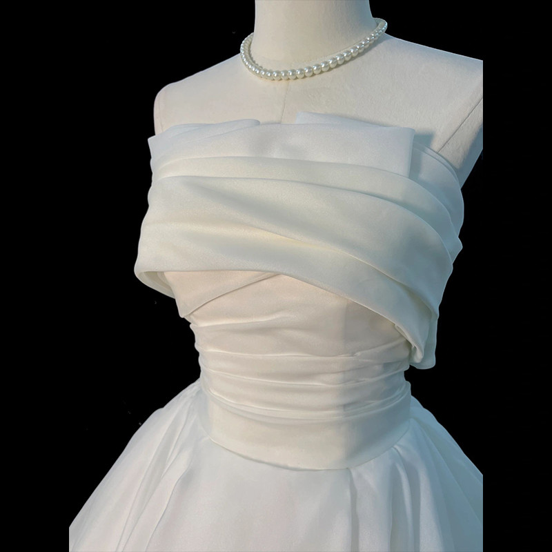Ivory organza strapless wedding dress with draped bodice and full A-line skirt
