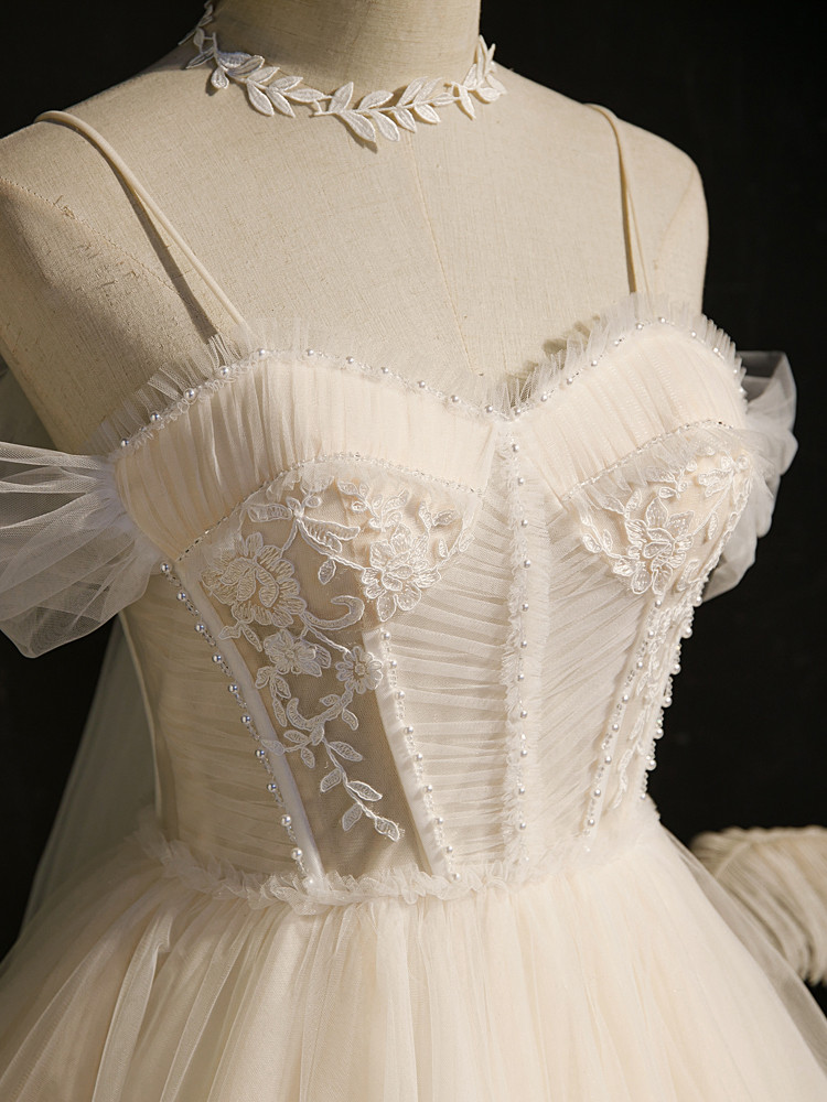Close up of ivory pleated tulle bodice with pearl beading and floral appliques on a homecoming dress