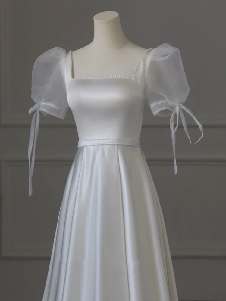 Ivory satin square neckline puff sleeve wedding dress with pearl trim