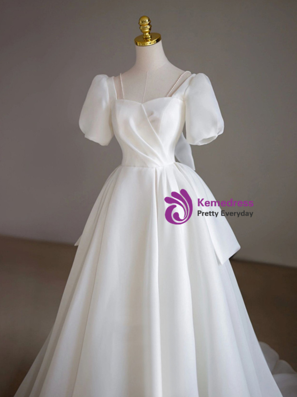 Ivory tulle wedding dress with pearl straps, puff sleeves, satin bow and full ball gown skirt