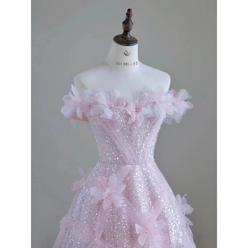 Close up detail of pink sequin tulle bodice with off shoulder 3D flowers and pearl centers