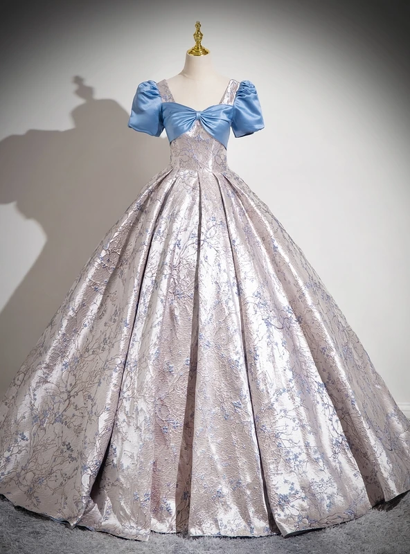 Light blue Quinceanera ball gown with an oversized blue bow and ornate silver blue skirt