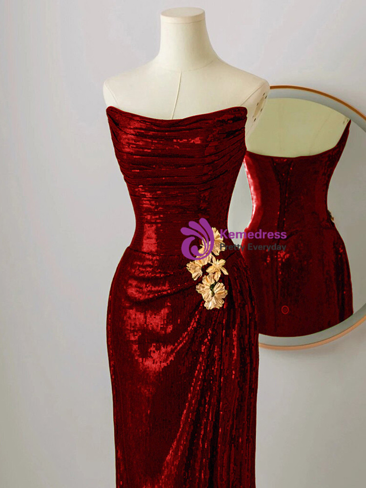 Close up detail of burgundy sequin mermaid prom dress with golden 3D flower and pleated bodice