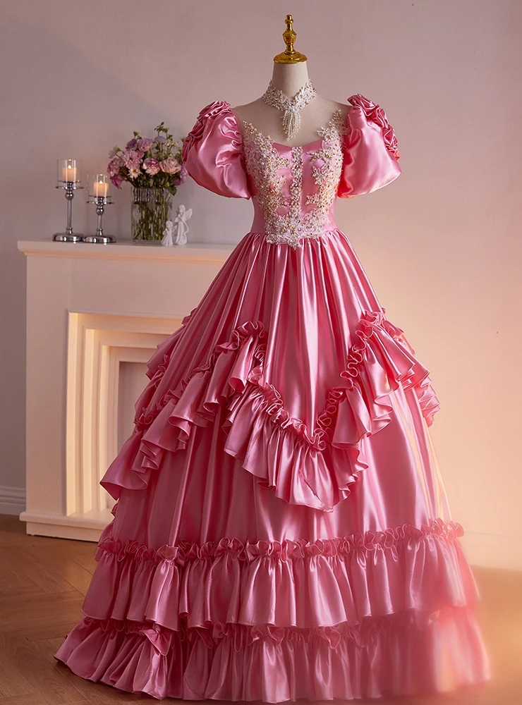 Pink satin ball gown quinceañera dress with floral appliqués and ruffled skirt