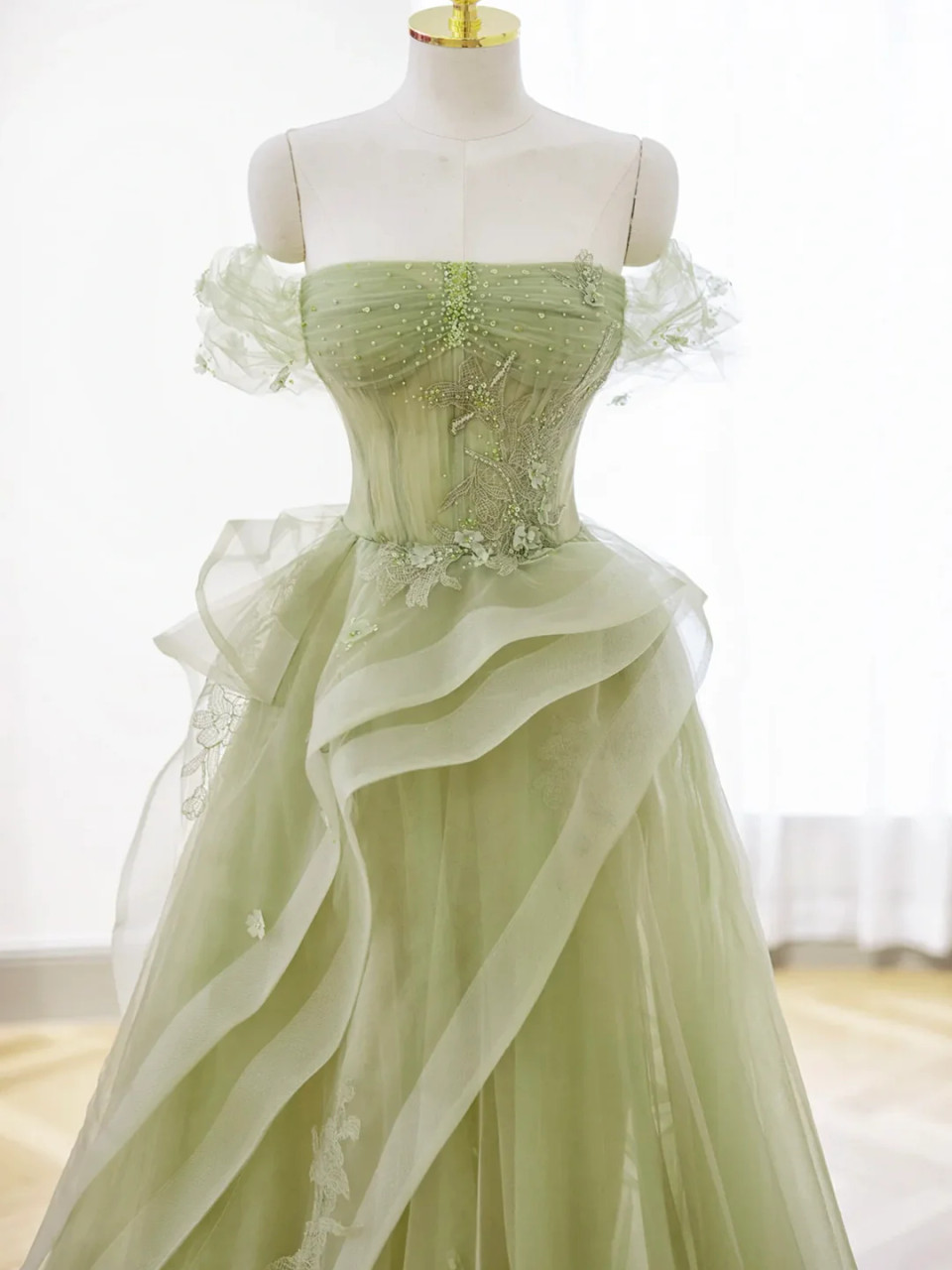 Close up detail of sage green tulle prom dress with corset bodice botanical lace embroidery and green beadwork