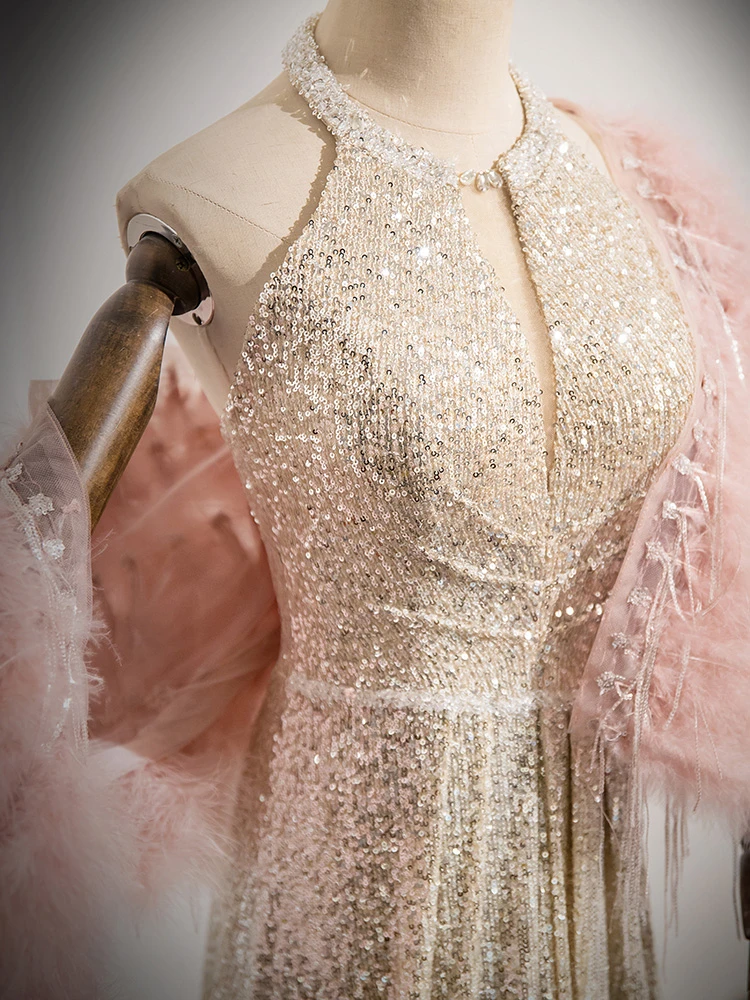 Close detail of champagne sequin bodice showing halter construction, fitted waist and flowing skirt