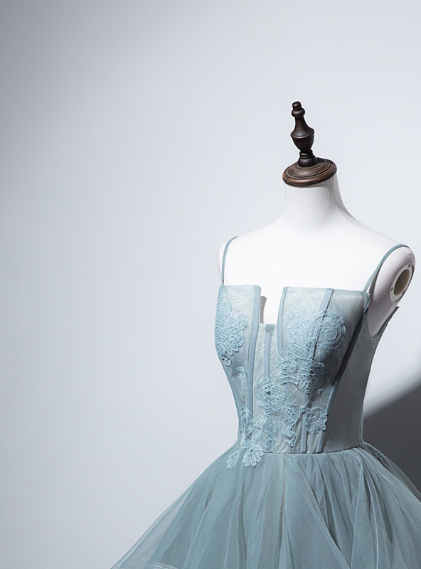 Green tulle prom dress detail showing floral lace corset bodice, spaghetti straps and layered tulle construction