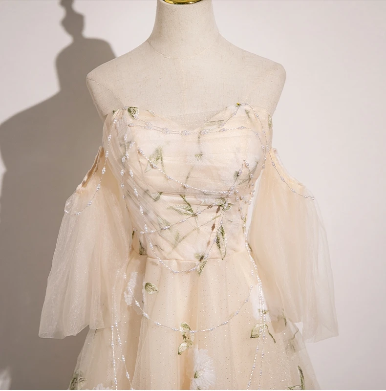 Gold beading and champagne tulle petal skirt detail on prom dress