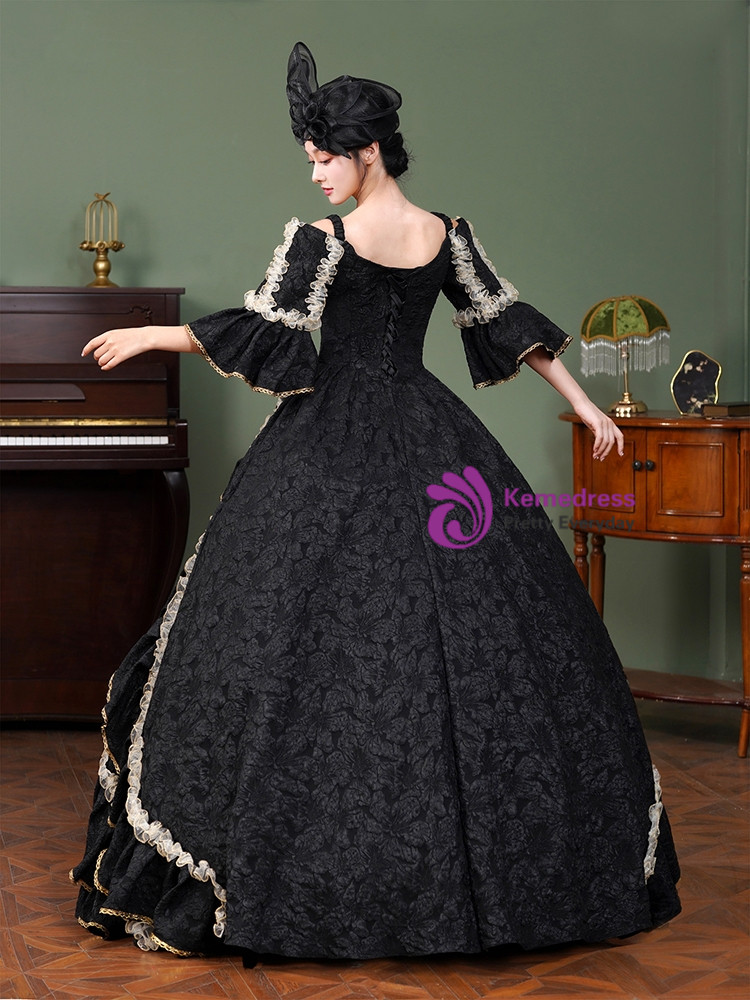 Black ball gown showing structured capelet, black and gold buttons and cascading ruffle skirt