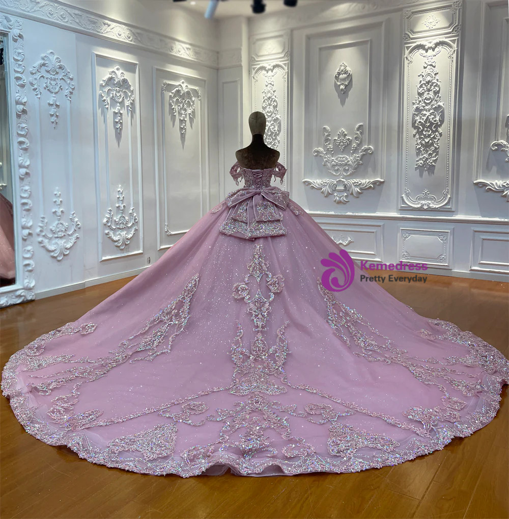 Close-up of structural bow and silver beadwork on blush pink tulle wedding dress