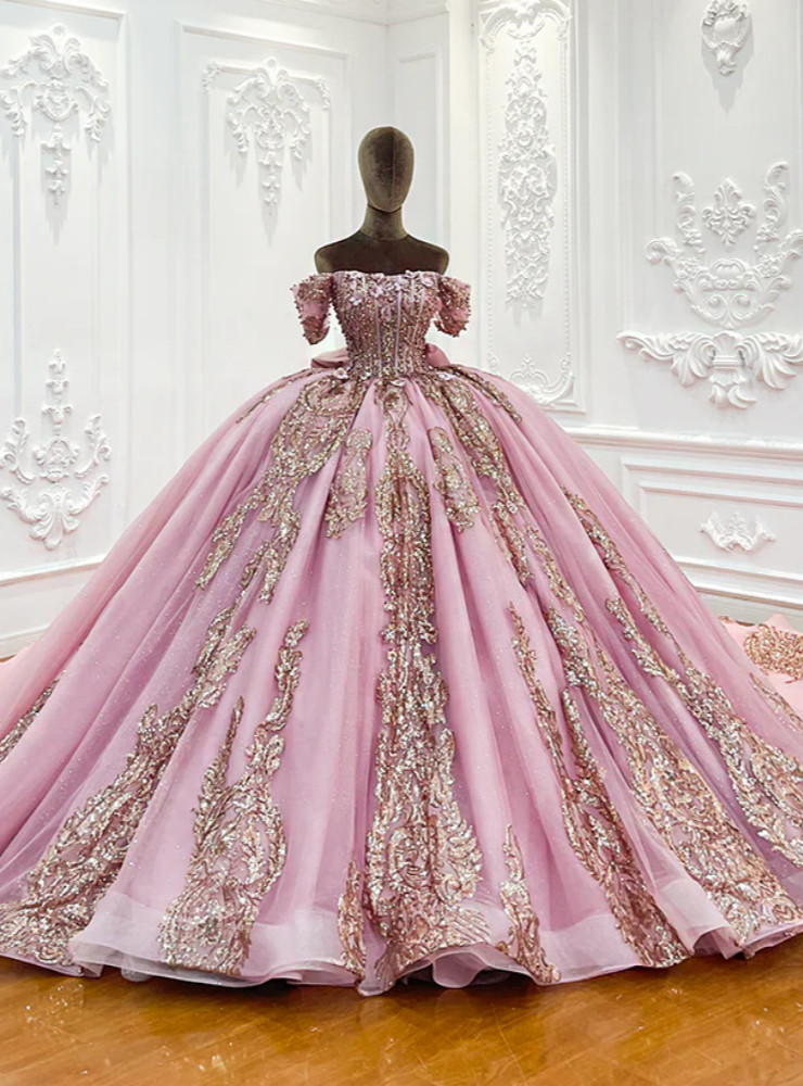 Queenly pink tulle sequins appliques wedding dress detail showing massive multi-tiered structured back bow, rose-gold and silver dual-tone embellishment, vertical sequined lace panels and scalloped cathedral train