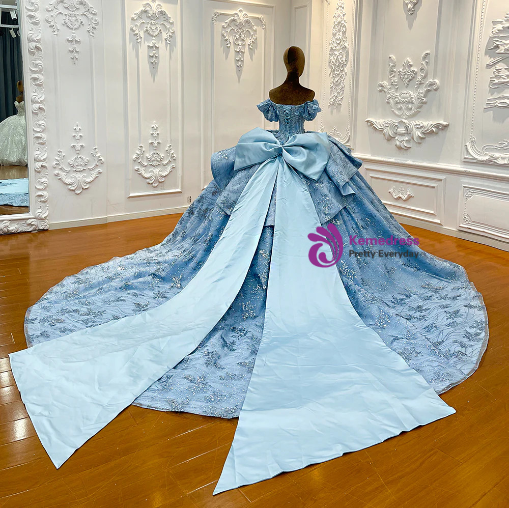 Back view of blue tulle strapless ball gown with oversized detachable bow train