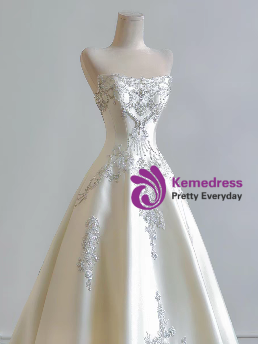 Full length ivory satin wedding gown with sweetheart strapless bodice and long train