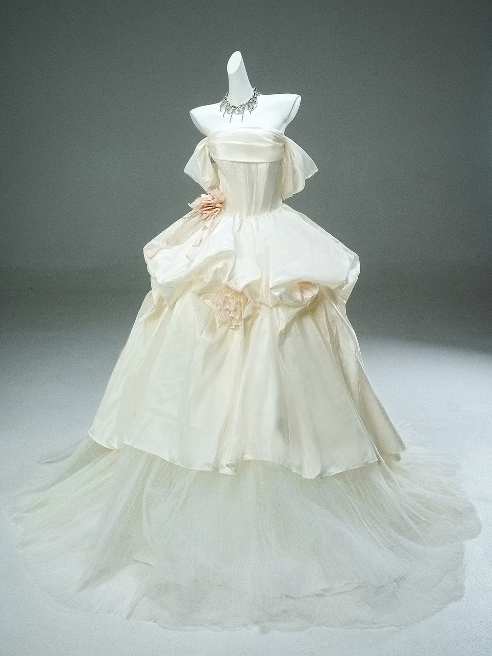 Ivory strapless corset prom dress with draped satin bodice, dramatic layered skirt and blush floral detail