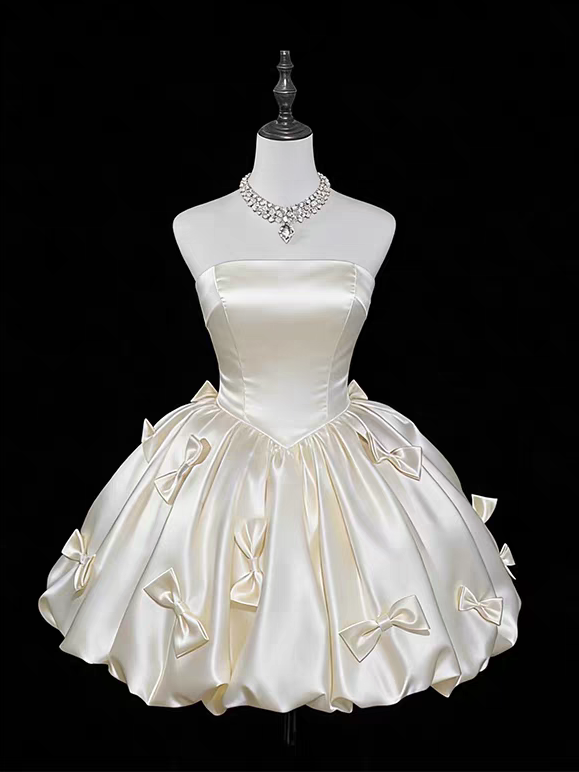 Champagne satin strapless short homecoming dress with multiple bow details and full gathered skirt