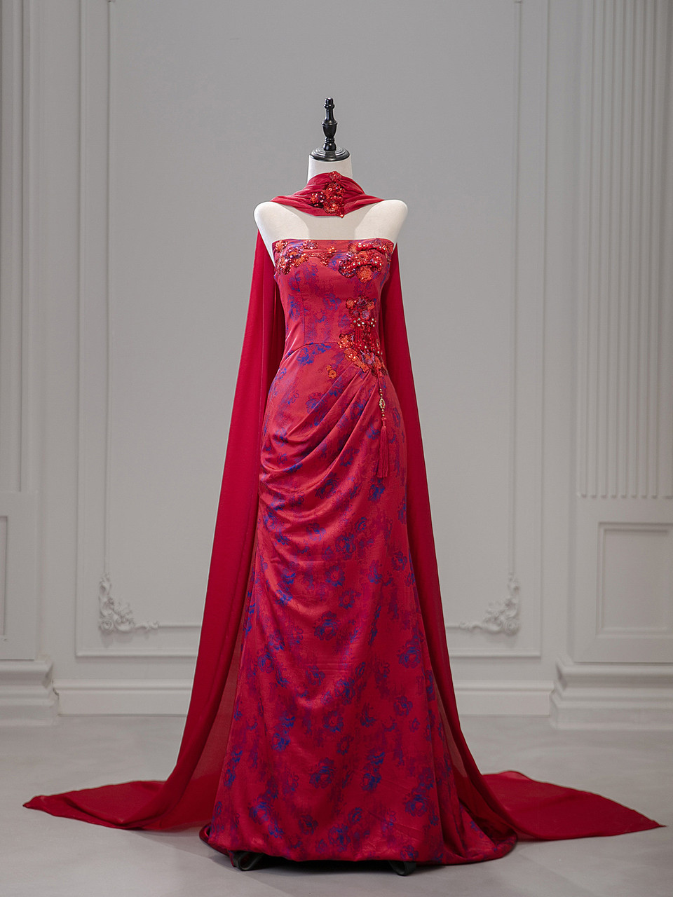 Burgundy strapless brocade prom dress with woven blue floral pattern and sheer chiffon cape