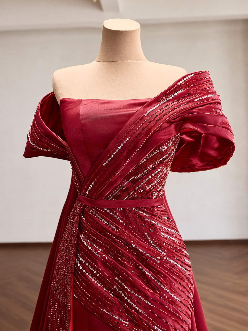 Upper front detail of the red satin gown with sculpted pleats and beaded bodice