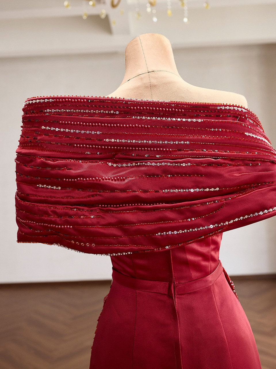 Upper back detail of the red satin mermaid gown with beaded pleats