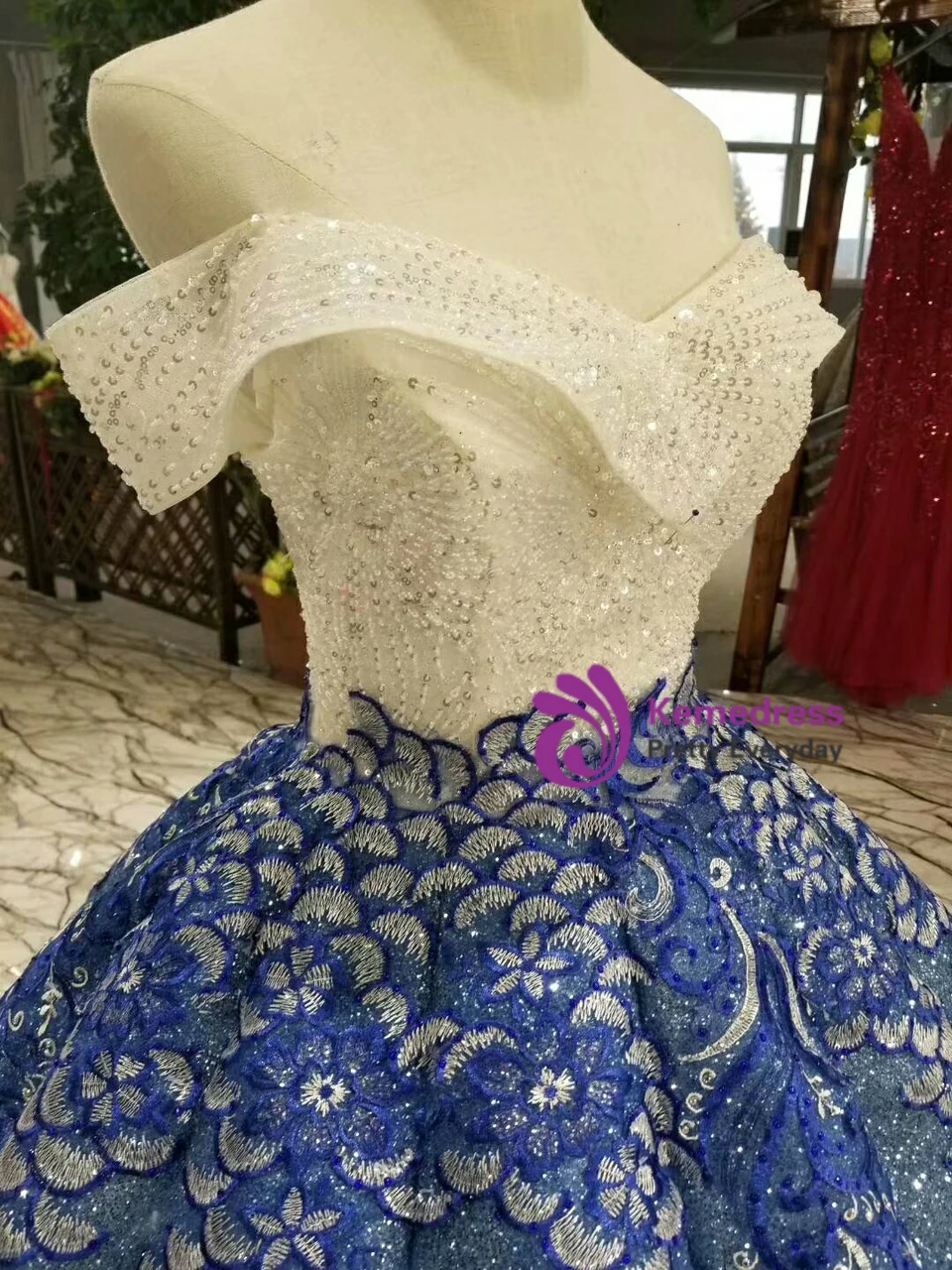 Blue floral lace appliques over tulle on the bodice and skirt of a sequined ball gown wedding dress