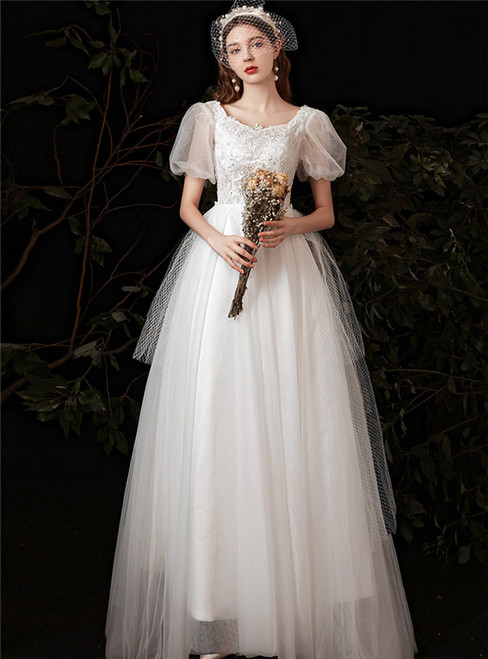 White tulle A-line wedding dress with a square neckline, short puff sleeves, and intricate floral appliqués, a vintage-inspired choice for a garden ceremony