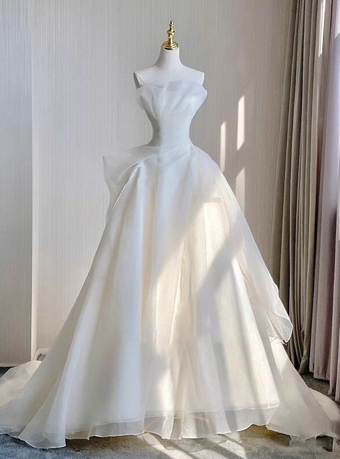 White organza strapless wedding dress with a full A-line skirt and a train, a light and airy choice for a grand entrance