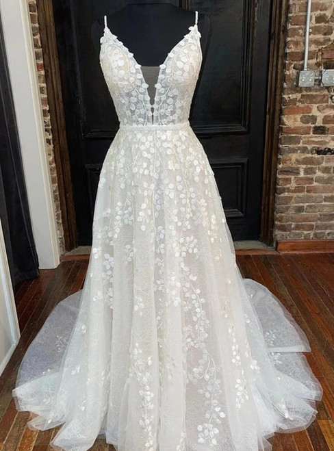 Close-up of the delicate floral appliqués on the bodice of a backless tulle wedding gown.