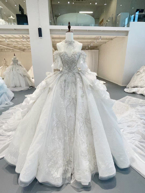 White off-the-shoulder ball gown wedding dress with puff sleeves, a beaded sweetheart bodice, and a full tulle skirt, a regal and romantic choice
