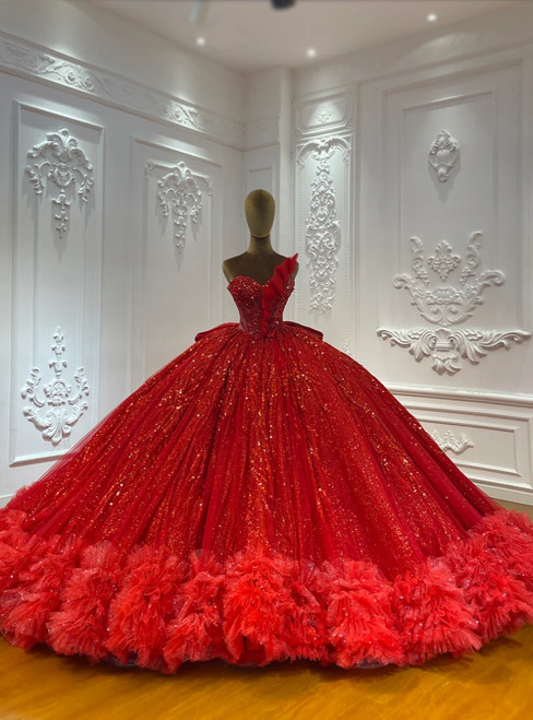 A strapless red sequin ball gown that commands attention, its firelit tulle bodice shimmering with dense sparkle against a full, dramatic skirt.