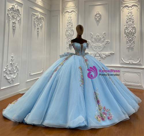 Close-up of the intricate floral appliques tracing the off-shoulder neckline of a soft blue tulle wedding dress, blending romance with elegance.