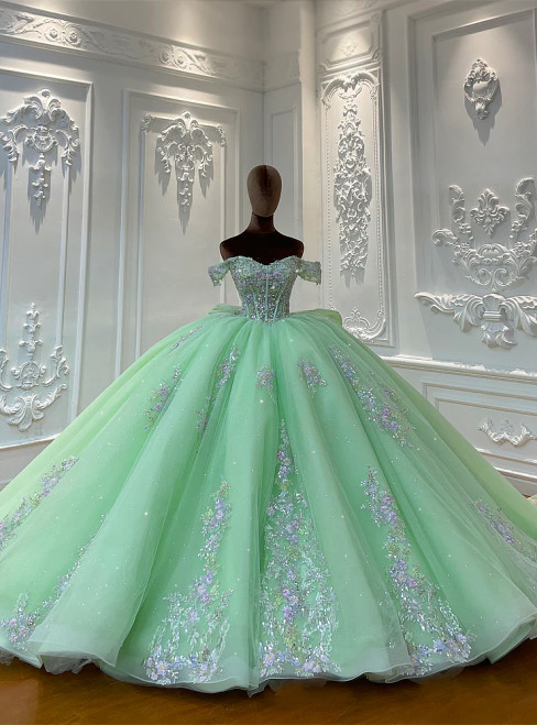 Green off-shoulder princess ball gown wedding dress with delicate lace appliques on a full tulle skirt.