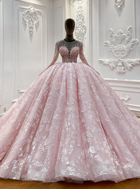 Pink tulle lace ball gown wedding dress with elegant long sleeves, a scoop neckline, and a full flowing skirt with delicate beading.