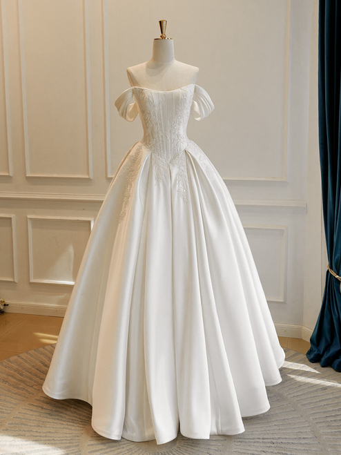 White satin off-the-shoulder wedding dress with delicate appliqués and a full A-line skirt, a modern classic for the romantic bride