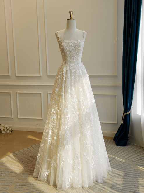 Lace A-line wedding dress with delicate straps and full floor-length skirt
