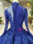 	Detailed view of lace appliqués and beading on long sleeves of a blue wedding gown