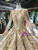 Close-up of intricate sequins and beading embellishments on luxury gold wedding gown